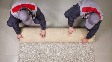 trabajadores-rodando-alfombra-piso-casa-vista-arriba_130111-2198
